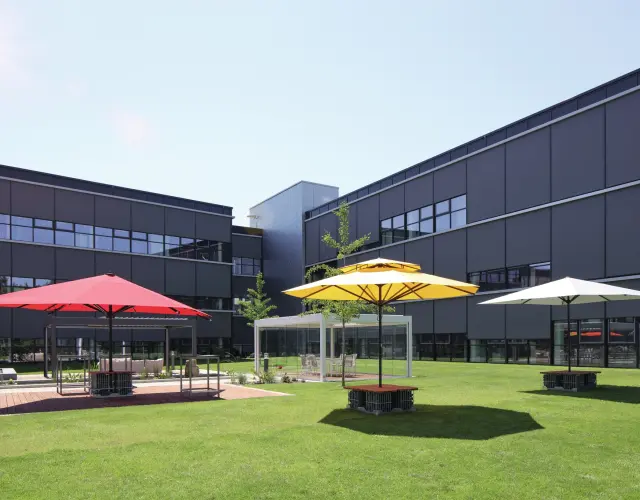 extérieur du WAREMA Campus avec des parasols