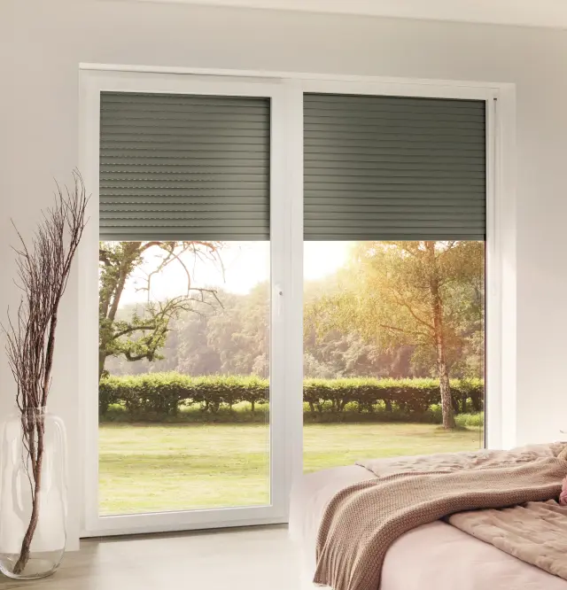 Rolladen mit Gurt an großen Fenstern mit schmaler Führung und geschlossenem Behang auf Terrasse