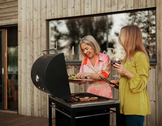 Zwei Freundinnen grillen auf der Terrasse