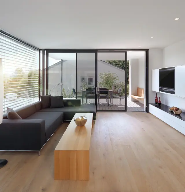 Modern living area with large window front on the left and an insect screen sliding door